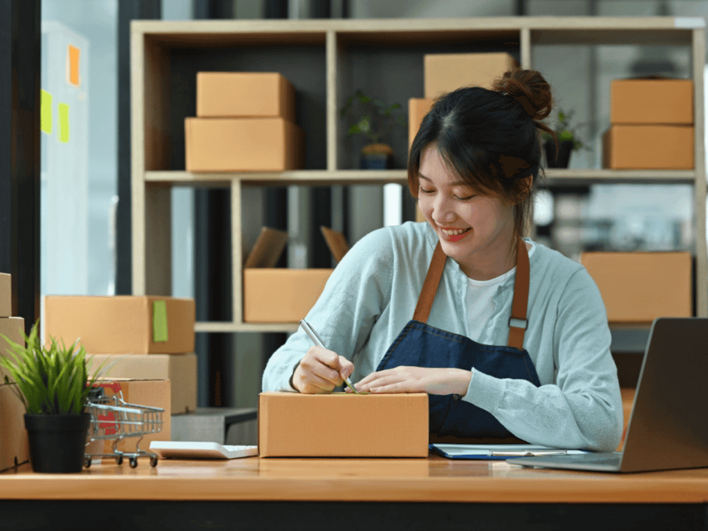 a female entrepreneur packs boxes from a storage unit.