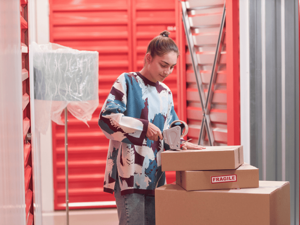 A young woman tapes up boxes to be held in her storage unit.