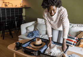 A woman is backing a suitcase for her summer holiday.