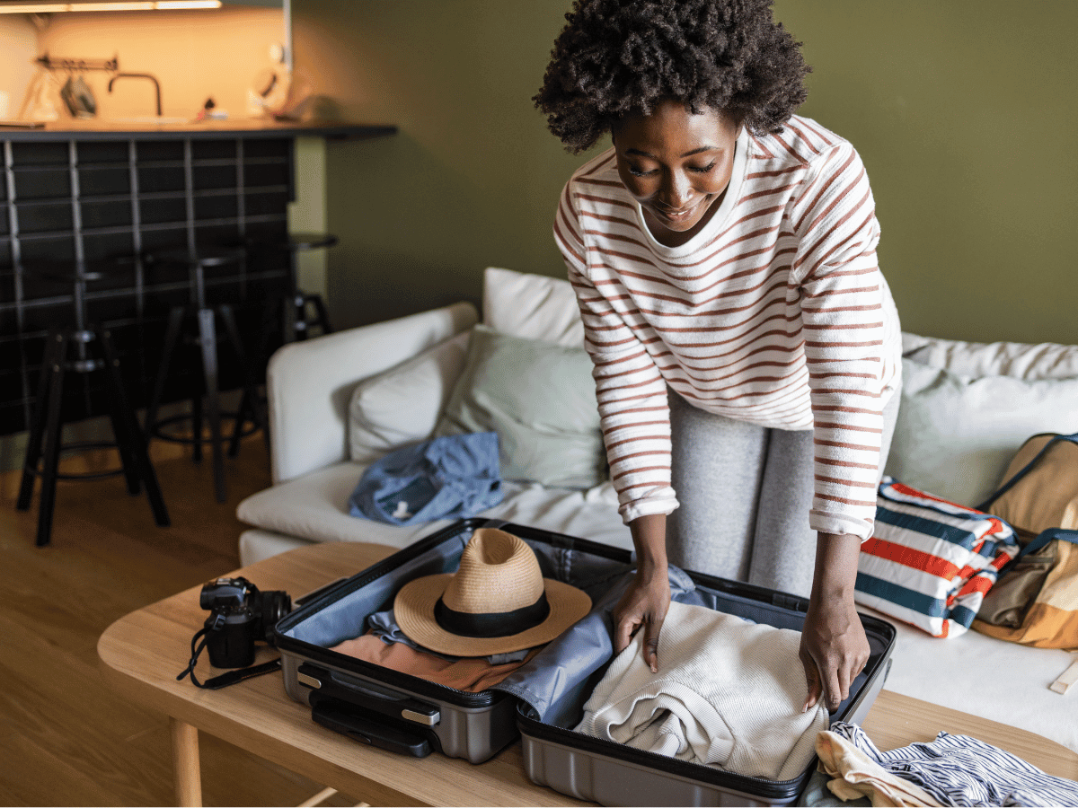 A woman is backing a suitcase for her summer holiday.